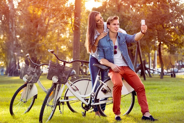 Pareja Sonriente Con Bicicletas Smartphone Parque Otoño —  Fotos de Stock