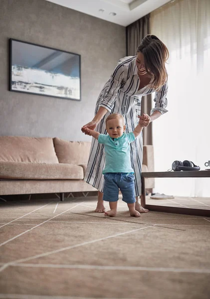 Eine Glückliche Mutter Hilft Und Unterstützt Das Kind Beim Gehen — Stockfoto