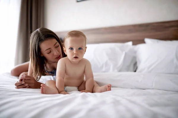 部屋のベッドの上のかわいい赤ちゃんの少年と母 — ストック写真