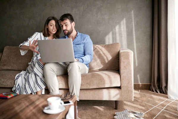 Happy couple searching something on laptop at home