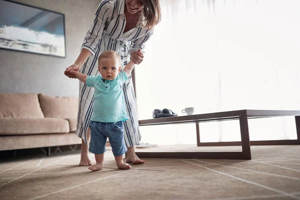 男の子の母親と一緒に歩いて学習子供が最初のステップを楽しんでいます — ストック写真