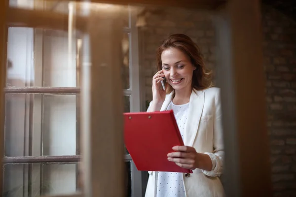 Хороший Жіночий Менеджер Біля Вікна Розмовляє Мобільному Телефоні Співробітниками — стокове фото