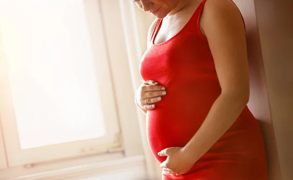 と期待の概念 ウィンドウで大きな腹を持つ幸せな妊娠中の女性のクローズ アップ — ストック写真
