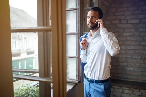 携帯電話で話しているオフィスで職場の青年実業家 — ストック写真