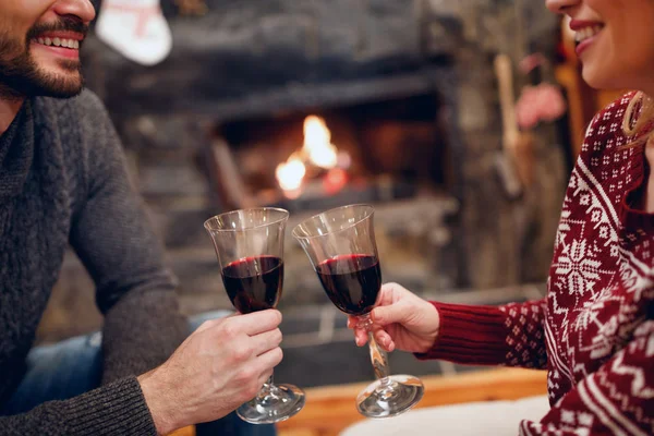 笑顔のカップルがロマンチックな Fireplac でおいしい赤ワインを乾杯 — ストック写真