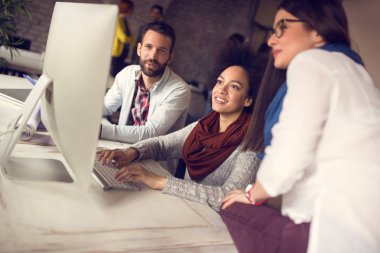 Office birlikte modern bilgisayar üzerinde çalışan genç pozitif kişilerde