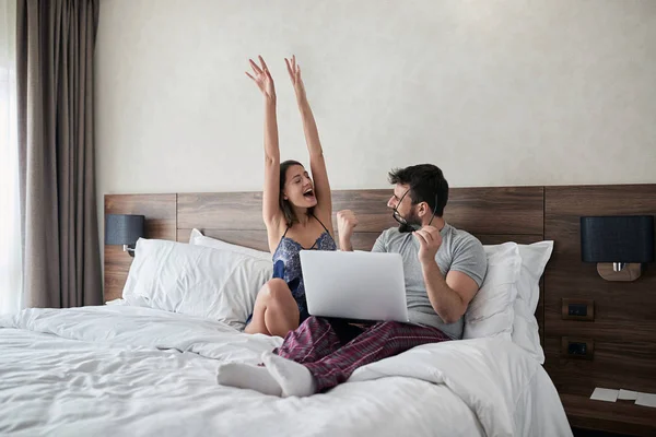 Feliz Casal Sorrindo Desfrutando Manhã Sentado Cama Com Laptop Surf — Fotografia de Stock