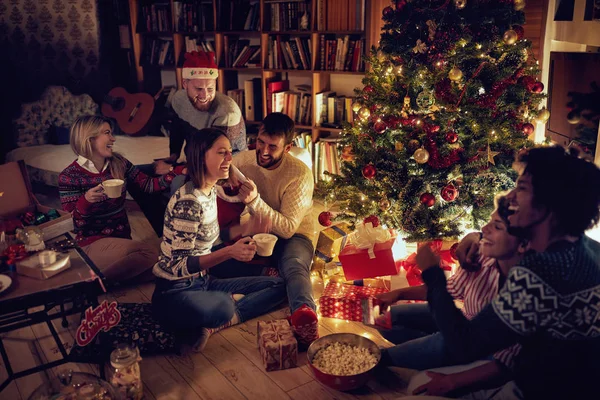 Grupo Amigos Felizes Sentados Lado Uma Árvore Natal Divertindo — Fotografia de Stock