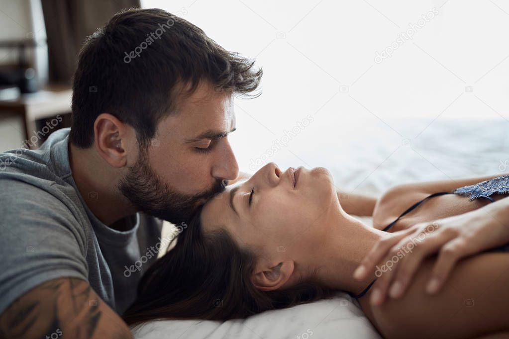 Sexy young couple being intimate in bed