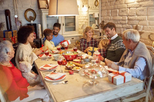 幸せな家族のクリスマス ディナーでお楽しみくださいし 一緒にプレゼント交換 — ストック写真