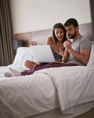 mutlu çift yatakta zevk ve eğlence için teknolojisini kullanarak