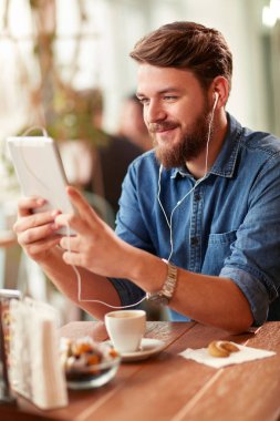 Genç modern adam cep telefonu ve restoran Kulaklığımda