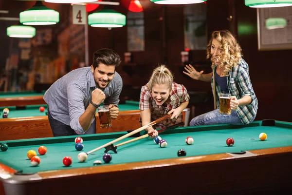 billiard game- young friends playing billiard in pub