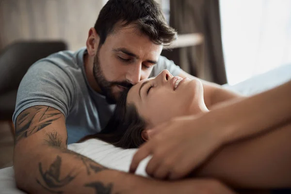 セクシーな若い男性とベッドでの親密な女性 — ストック写真