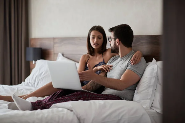 年轻的男人和女人在床上笔记本电脑工作的 — 图库照片