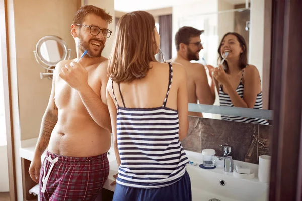若い男と女の自宅浴室で彼らの歯を磨く — ストック写真