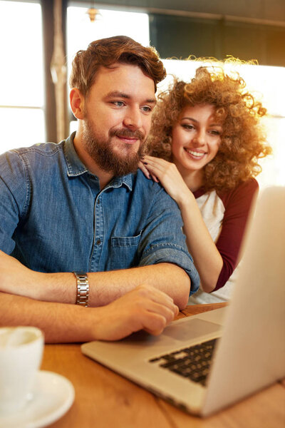Couple looking something on laptop in restaurant