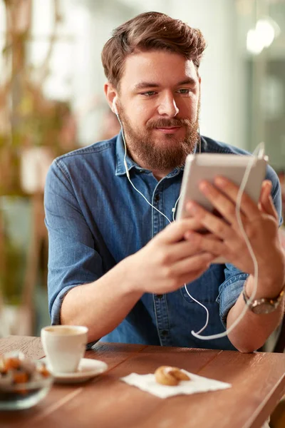 Kafede Adam Cep Telefonuyla Kulaklık Kullanarak Müzik Dinlemek — Stok fotoğraf