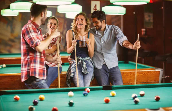 Grupo de amigos desfrutando de cerveja e jogando bilhar — Fotografia de Stock