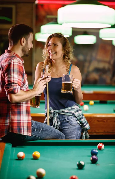 Donna sorridente flirtare con l'uomo durante il gioco del biliardo — Foto Stock