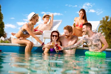 İçki şişeleri ile toasting üç genç erkek ve kadın çift