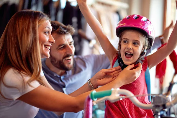 Сім'я купує новий велосипед для маленької дівчинки в магазині велосипедів — стокове фото