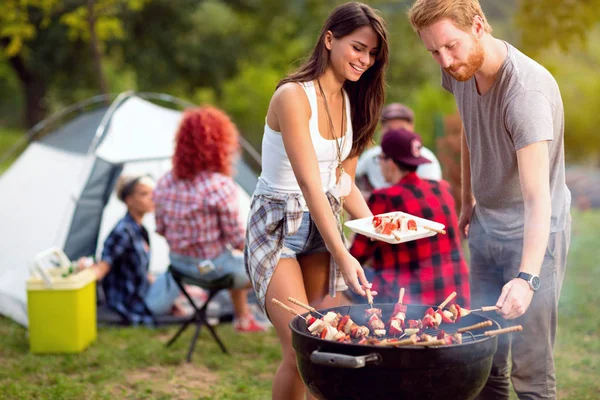 Guy og lassie sætte grillede spyd på tallerken - Stock-foto