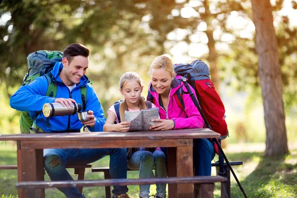 Família caminhadas relaxar sentado e olhar no mapa — Fotografia de Stock