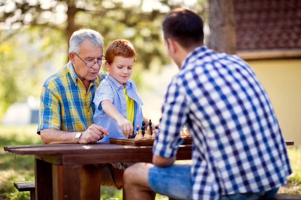 Família se divertindo e jogando xadrez — Fotografia de Stock