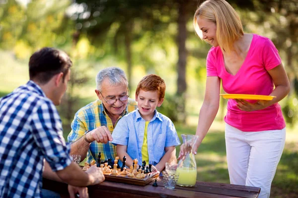 Família feliz relaxante jogar xadrez — Fotografia de Stock