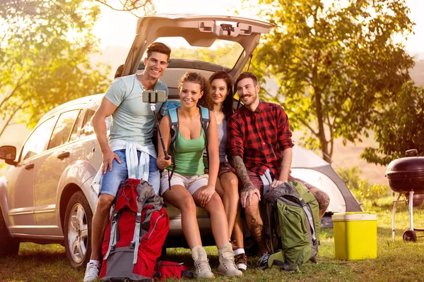 Leende människor på campingtur i den stammen gör selfie — Stockfoto