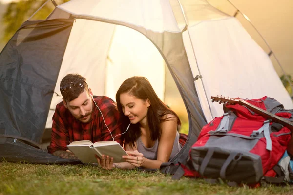 Par i telt læser en bog - Stock-foto