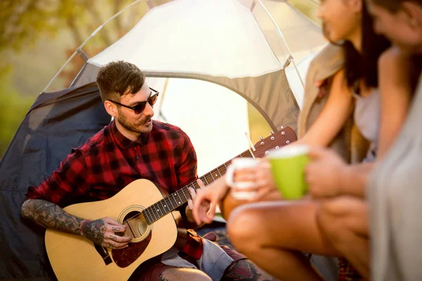 Hipster mannen med gitarr på campingtur — Stockfoto