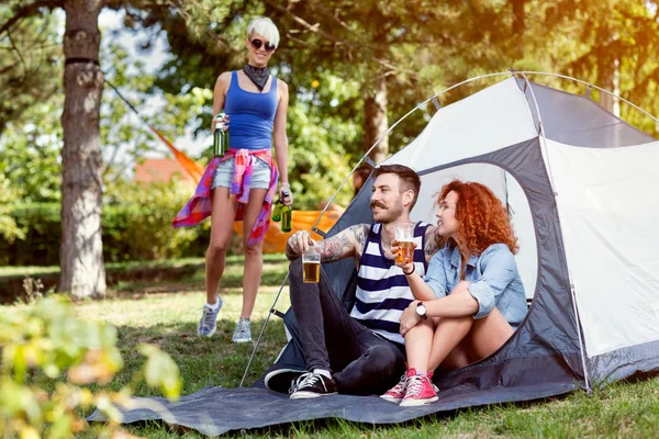 Femeia aduce o sticlă de bere prietenilor ei în camping — Fotografie, imagine de stoc