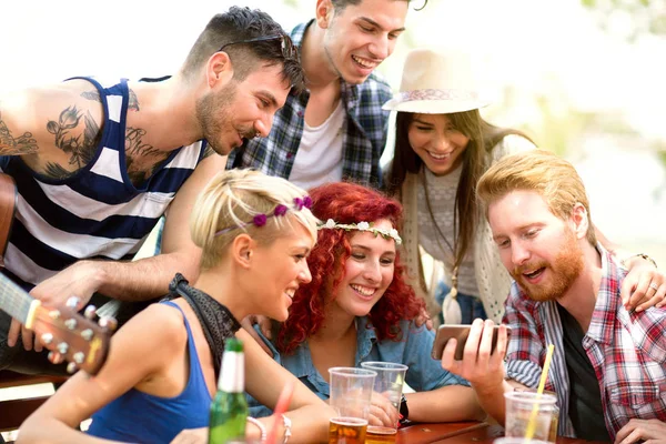 Молодые люди веселятся во время просмотра чего-то интересного на мобильном телефоне — стоковое фото