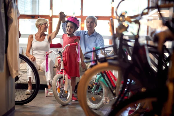 Abuelos comprando nueva bicicleta para poco gir —  Fotos de Stock