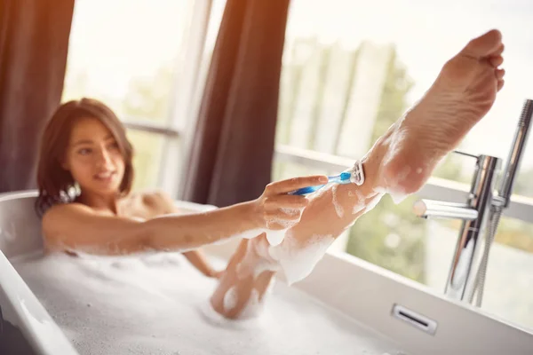 Scheren benen van de vrouw in de badkamer - ontharing met razo — Stockfoto