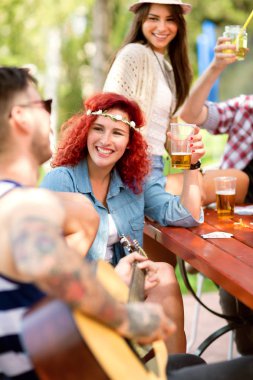 Genç mutlu kıvırcık kırmızı saçlı kız tost olan gitar adamla