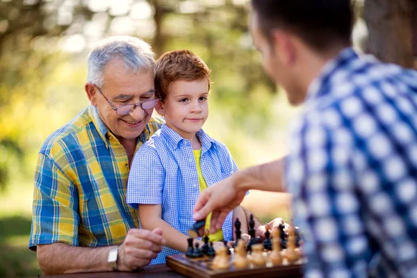 Hombre mayor jugando ajedrez en una mesa — Foto de Stock
