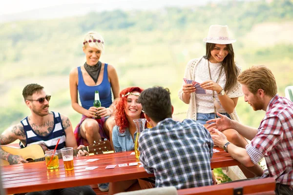 Grupp unga vänner njuta av spelkort, gitarr och drycker — Stockfoto