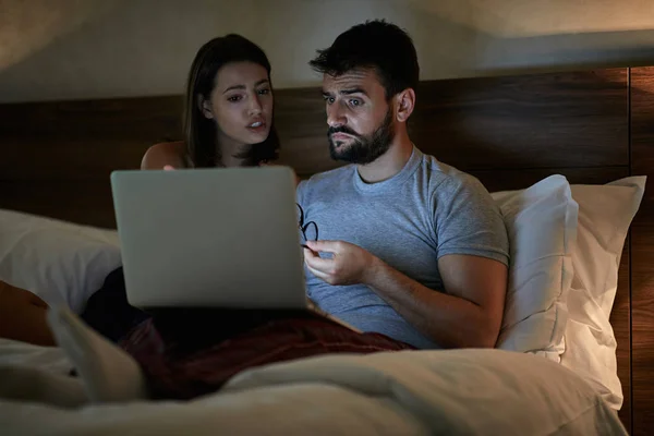 Casal com laptop assistindo filme na cama — Fotografia de Stock