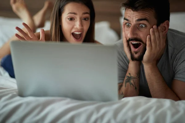 Namorado e namorada surfar a rede na cama — Fotografia de Stock