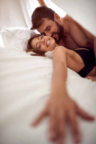 Счастливая пара влюбленных, занимающихся любовью в постели страстный секс — стоковое фото