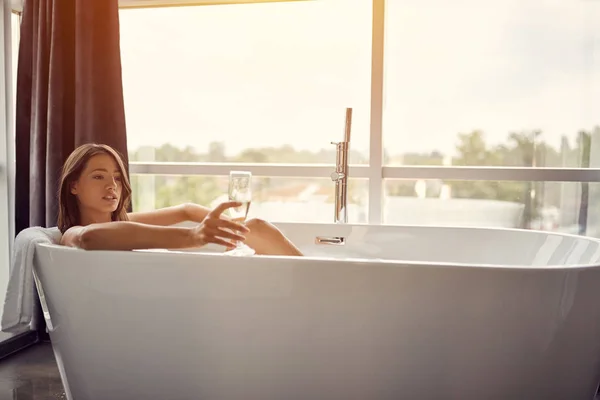 Rilassarsi nel bagno- bella donna nel bagno bere champagne — Foto Stock