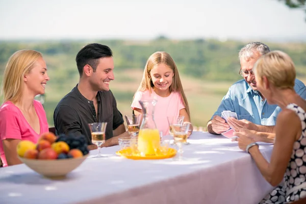 Familia jugando cartas al aire libre — Foto de Stock