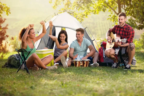 Fröhliche Menschen mit Spaß an der Musik auf dem Campingausflug — Stockfoto