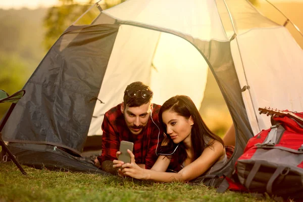 Para camping w namiocie i przy użyciu telefonu — Zdjęcie stockowe