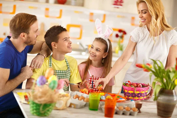 Mujer con familia preparando cesta de Pascua con huevos — Foto de Stock