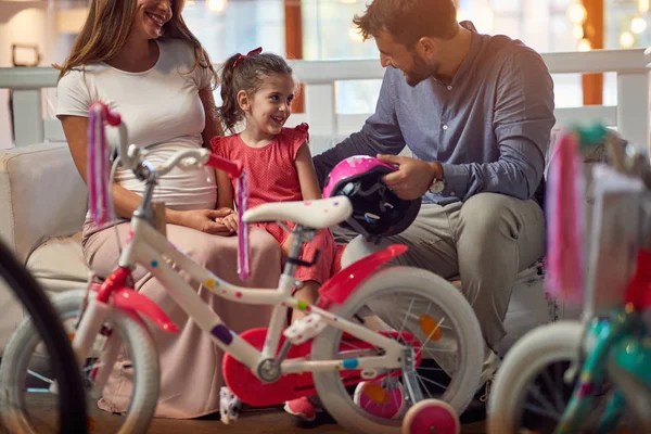 Jovem família de compras nova bicicleta para criança na loja de bicicletas — Fotografia de Stock