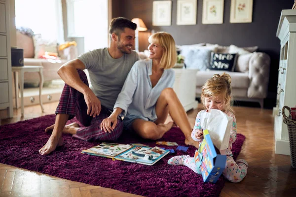 Sonrientes padres enamorados de su hija en la sala de estar — Foto de Stock